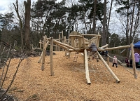 Spielplatz An den der Rehwiese Spielplatz An den der Rehwiese: Auf einem Hügel steht ein Holz-Klettergerüst, das an eine Spinne erinnert.
